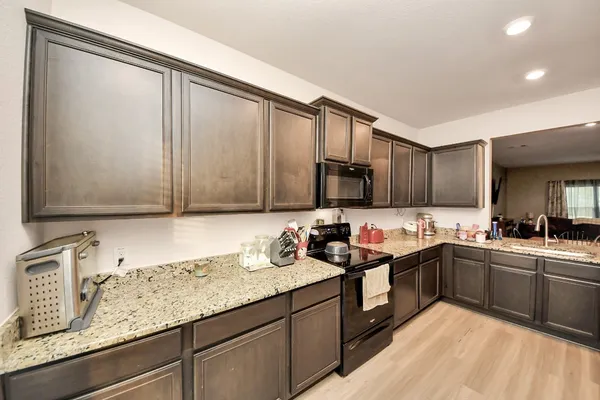 a kitchen with stainless steel appliances granite countertop a sink stove and cabinets