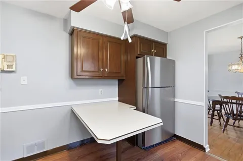 a kitchen with a refrigerator a stove and a dining table
