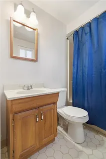 a bathroom with a toilet sink vanity and mirror
