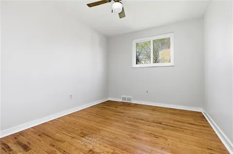 an empty room with a window and wooden floor
