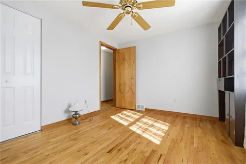a view of a room with wooden floor and a ceiling fan