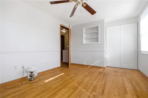 a view of a livingroom with wooden floor and a ceiling fan