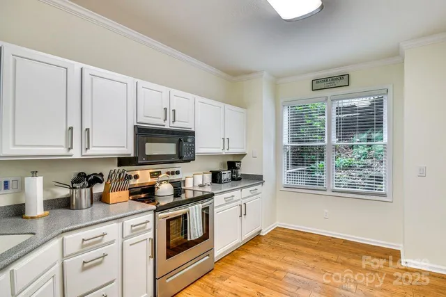a kitchen with granite countertop white cabinets and white appliances