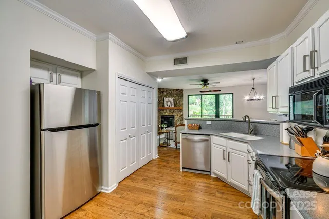 a kitchen with a sink a refrigerator and cabinets