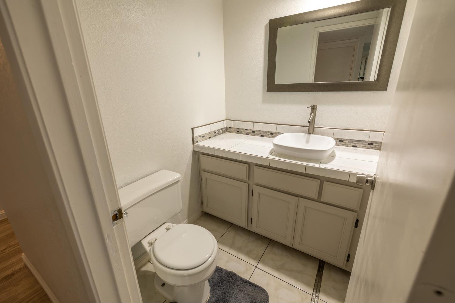 3700 Tully Road, Unit 5 Modesto, CA 95356 - Photo 12 of 38 a bathroom with a toilet sink and mirror