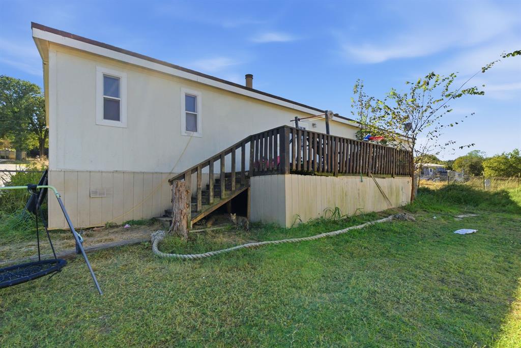 406 Hilltop Meadows Court Springtown, TX 76082 - Photo 3 of 33 a view of a backyard with grass and a bench