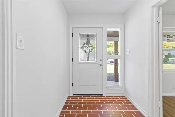 a view of a hallway with wooden floor and a dining room