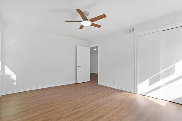 a view of a livingroom with a ceiling fan and wooden floor