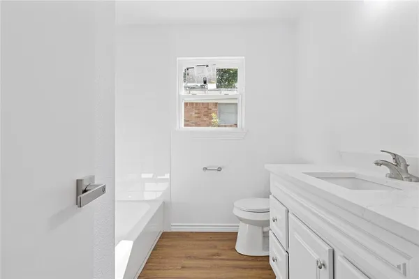 a bathroom with a granite countertop toilet a sink and a mirror