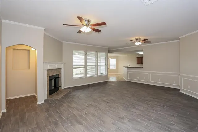 a view of empty room with wooden floor and fireplace