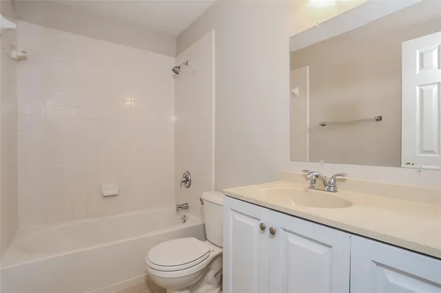 a bathroom with a granite countertop sink a toilet and shower