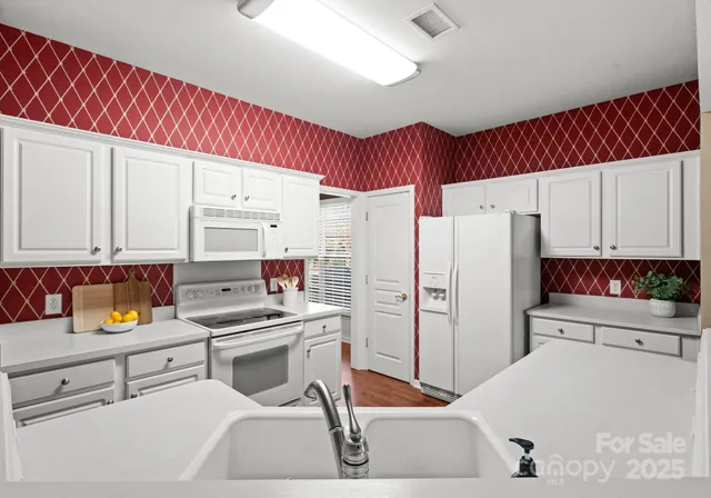 a kitchen with a refrigerator sink and cabinets