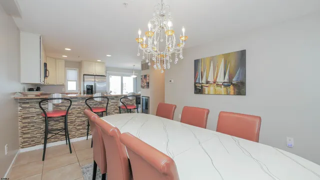 a kitchen with stainless steel appliances granite countertop a stove a sink a microwave a refrigerator and chairs