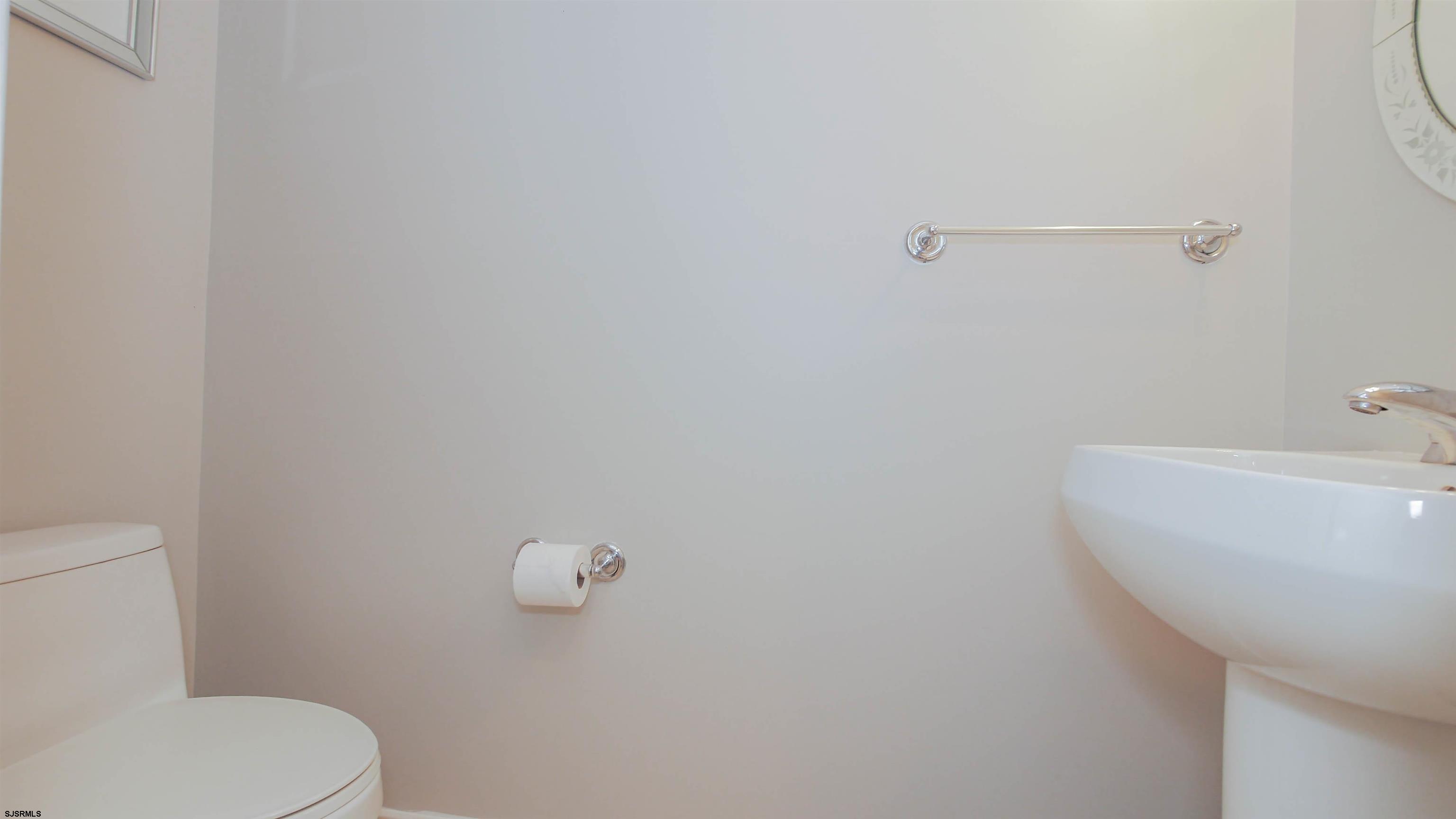 137 South Berkley Square, Unit B Atlantic City, NJ 08401 - Photo 21 of 42 a bathroom with a sink a toilet and mirror