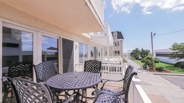 a kitchen with stainless steel appliances granite countertop a stove a sink a microwave a refrigerator and chairs