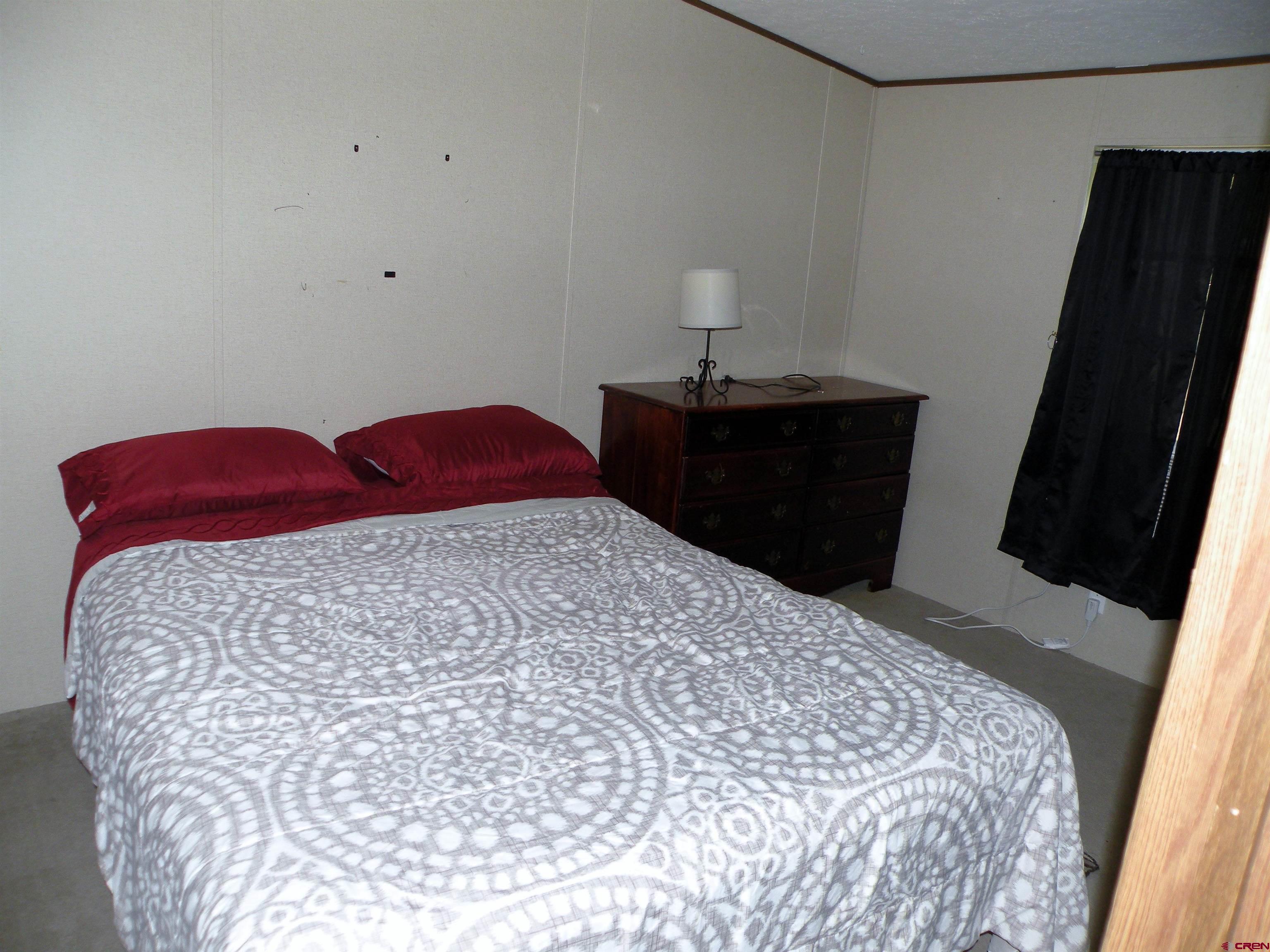 27936 CC Road Nucla, CO 81424 - Photo 5 of 10 a bedroom with a bed and a lamp on the dresser