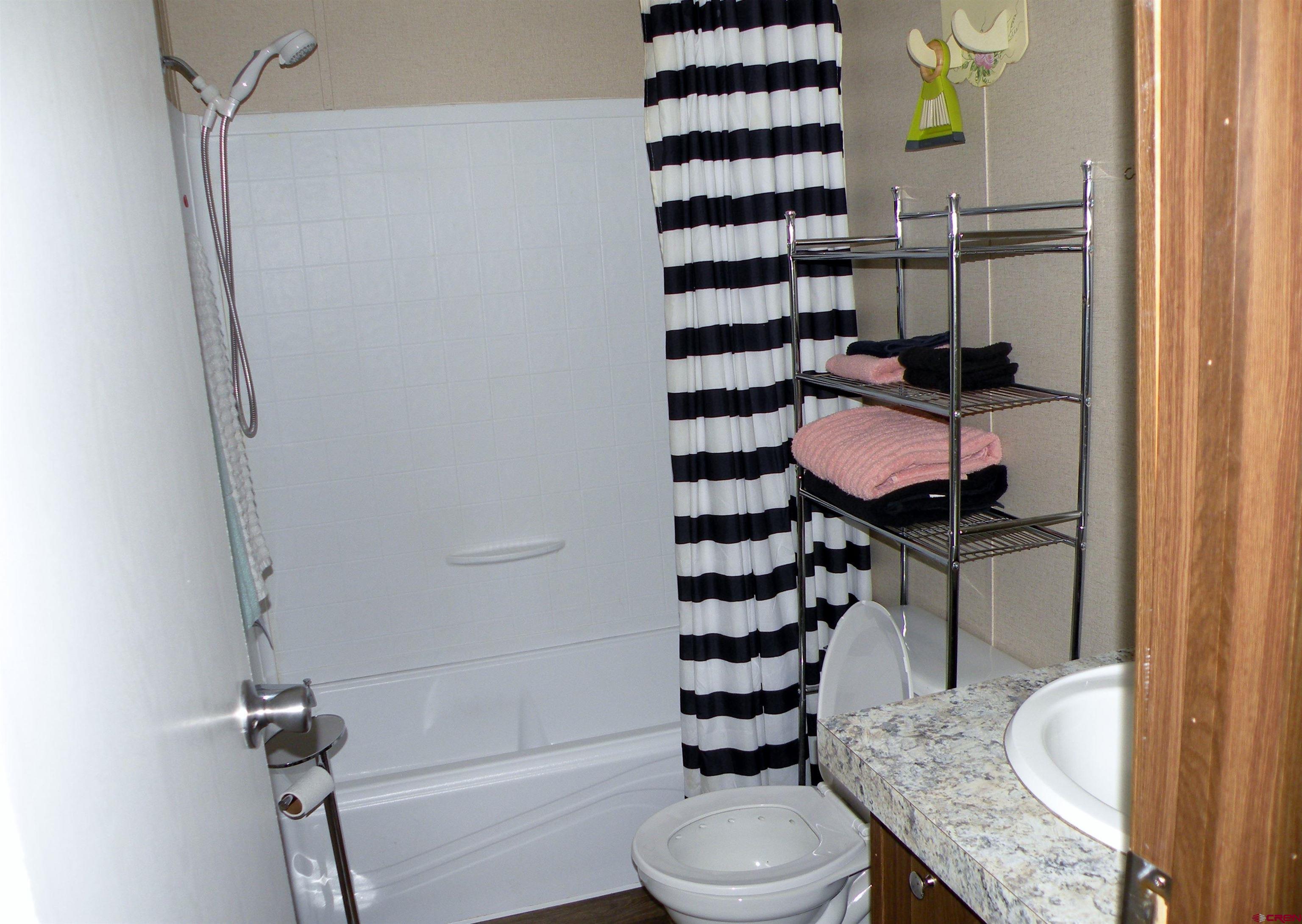 27936 CC Road Nucla, CO 81424 - Photo 8 of 10 a bathroom with a granite countertop toilet sink and mirror