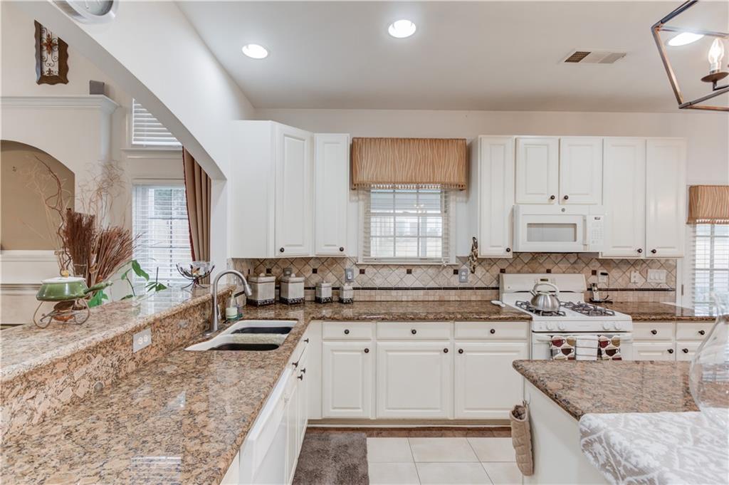 2648 Stockbridge Way Dacula, GA 30019 - Photo 17 of 59 a kitchen with stainless steel appliances granite countertop a sink stove and cabinets
