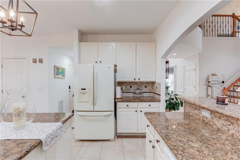2648 Stockbridge Way Dacula, GA 30019 - Photo 18 of 59 a large kitchen with granite countertop a sink a stove and cabinets