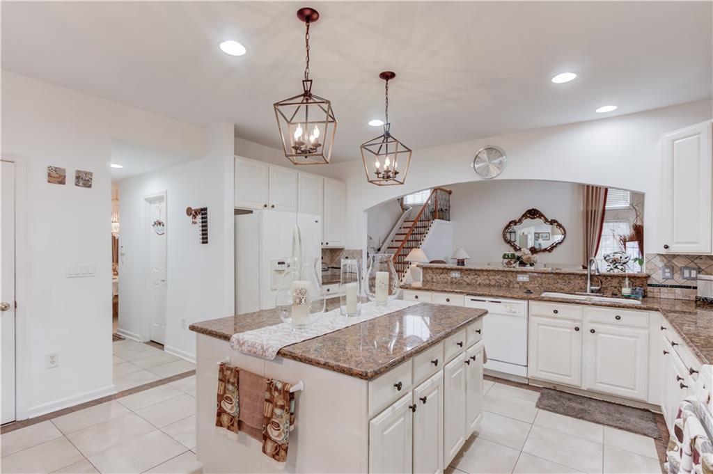 2648 Stockbridge Way Dacula, GA 30019 - Photo 19 of 59 a kitchen with stainless steel appliances granite countertop a sink stove and refrigerator