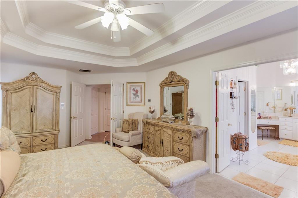 2648 Stockbridge Way Dacula, GA 30019 - Photo 30 of 59 a spacious bedroom with a bed and a chandelier