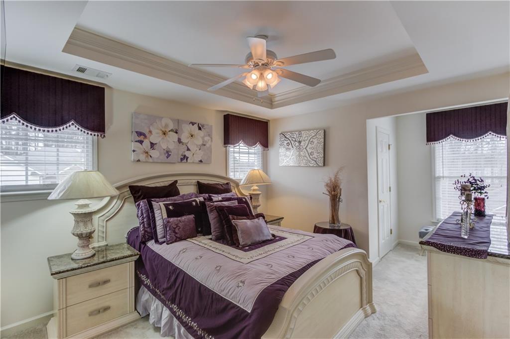 2648 Stockbridge Way Dacula, GA 30019 - Photo 35 of 59 a bedroom with a bed and a chandelier