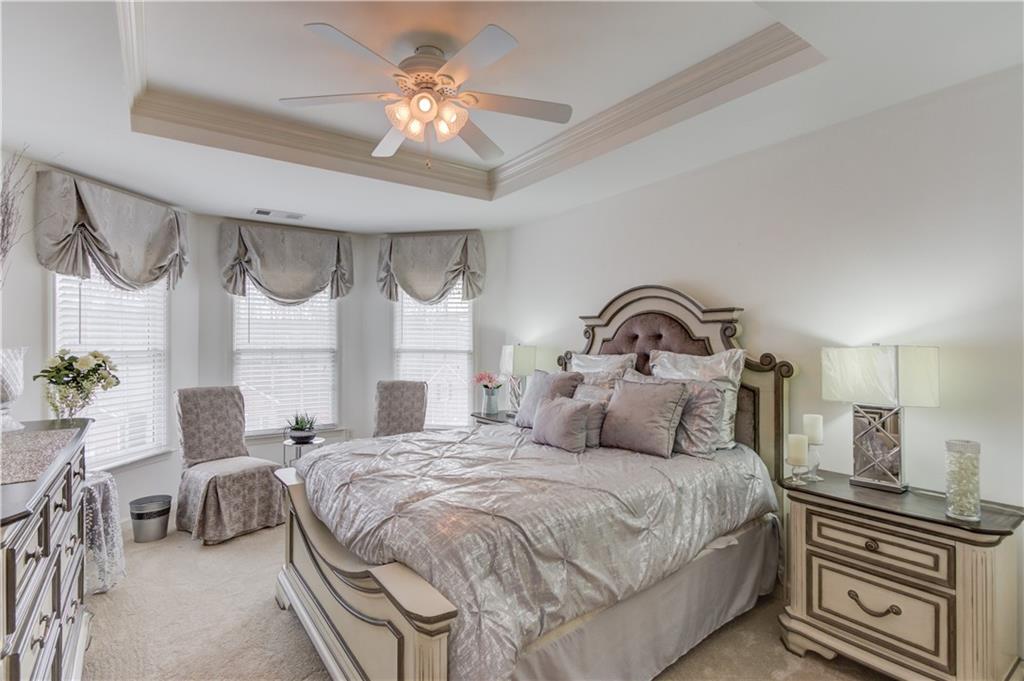 2648 Stockbridge Way Dacula, GA 30019 - Photo 38 of 59 a bedroom with a bed and a chandelier