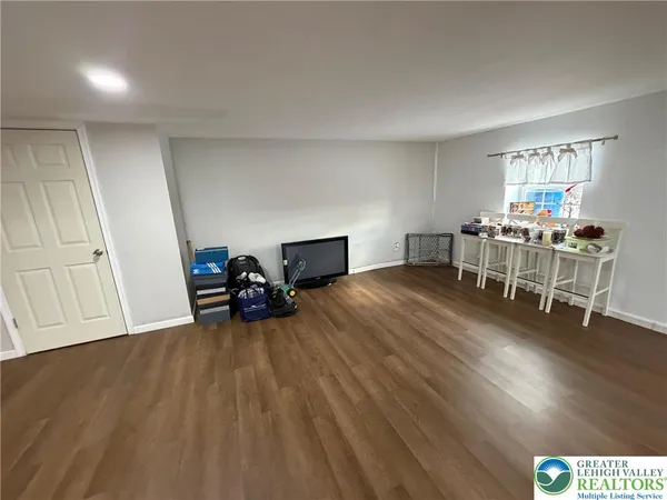 a view of a room with wooden floor furniture and windows