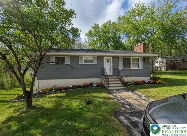 a front view of house with yard and green space