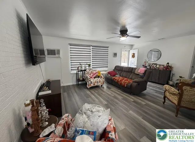 a living room with furniture a flat screen tv and a window