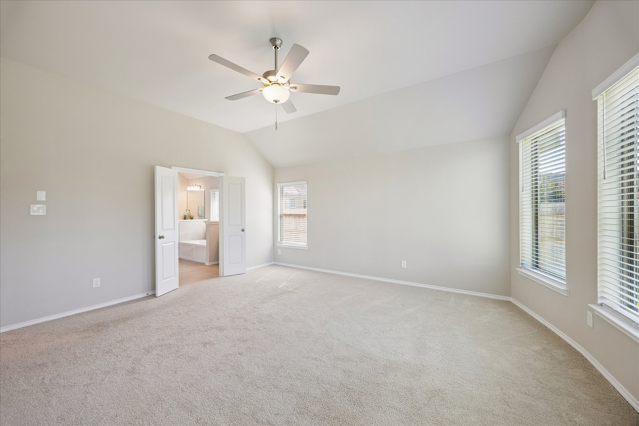 3212 Bright Maple Dr Spring Spring, TX 77386 - Photo 22 of 28 This photo of the primary bedroom shows a glimpse of the en suite bathroom as well as the ceiling fan for easy sleeping.