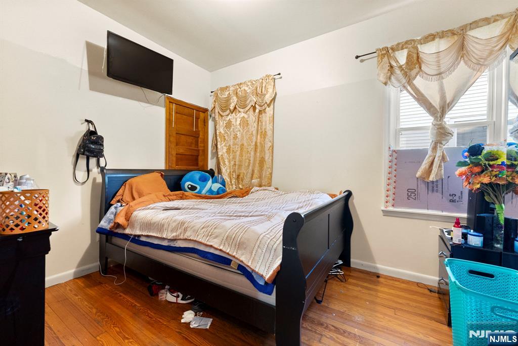 91 Headley Terrace Irvington, NJ 07111 - Photo 16 of 50 a bedroom with a bed and a flat tv screen on dresser