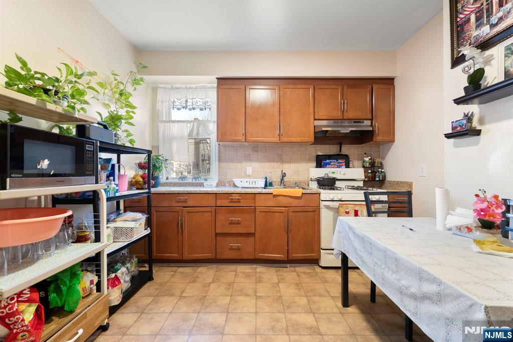 91 Headley Terrace Irvington, NJ 07111 - Photo 20 of 50 a kitchen with stainless steel appliances a stove a sink and a refrigerator