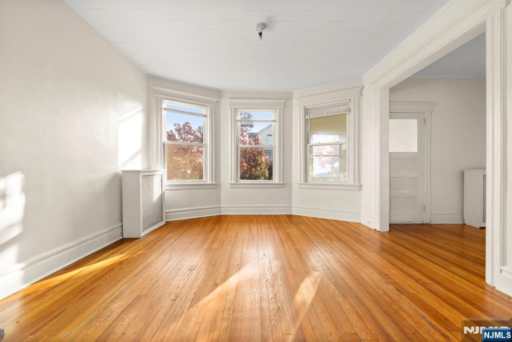 91 Headley Terrace Irvington, NJ 07111 - Photo 31 of 50 a view of an empty room with wooden floor and a window
