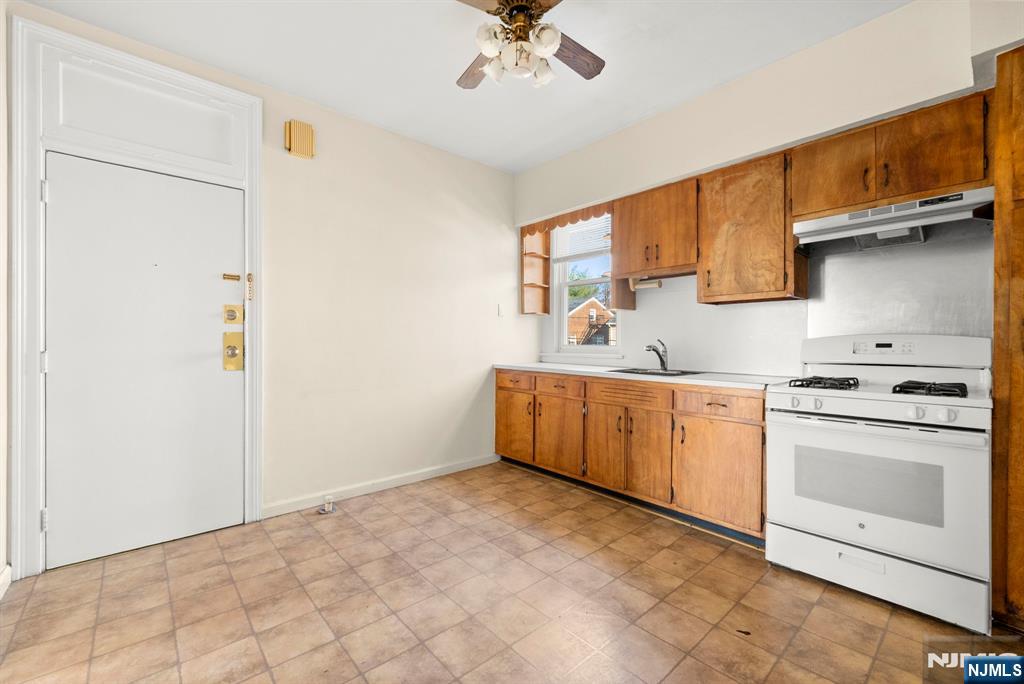 91 Headley Terrace Irvington, NJ 07111 - Photo 41 of 50 a kitchen with granite countertop a sink stainless steel appliances and cabinets