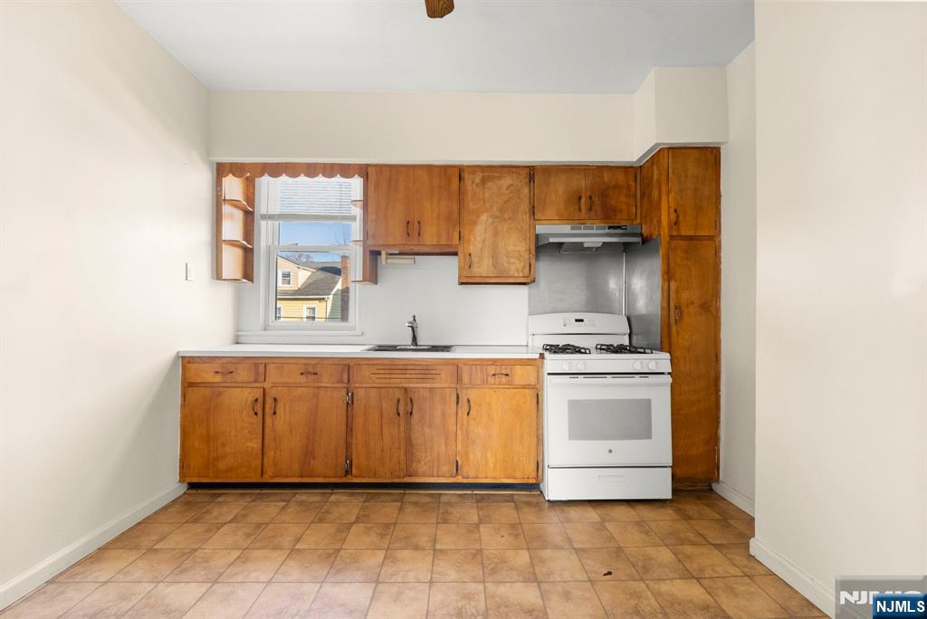 91 Headley Terrace Irvington, NJ 07111 - Photo 42 of 50 a kitchen with stainless steel appliances granite countertop a sink and a stove