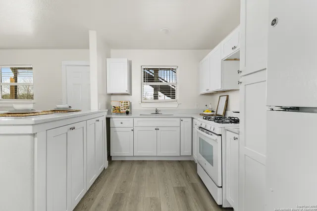a kitchen with white cabinets and white appliances