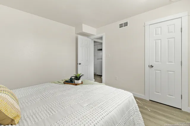 a bedroom with a bed and wooden floor