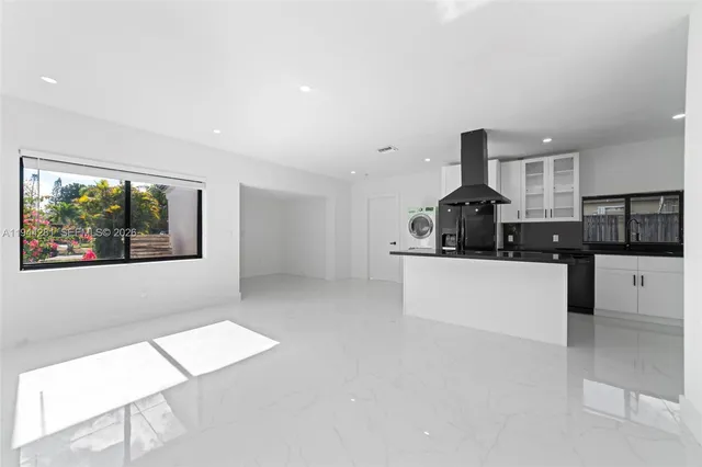 a kitchen with stainless steel appliances kitchen island sink refrigerator and microwave