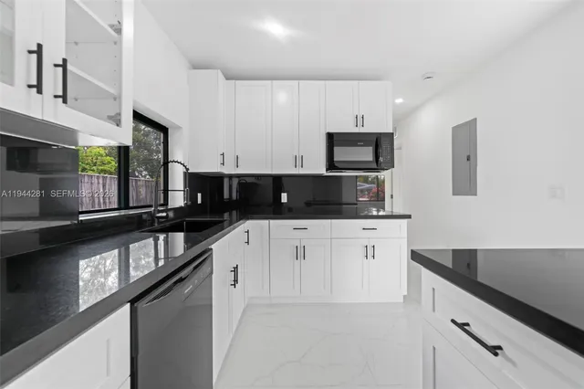 a kitchen with stainless steel appliances kitchen island granite countertop a refrigerator a stove and a sink