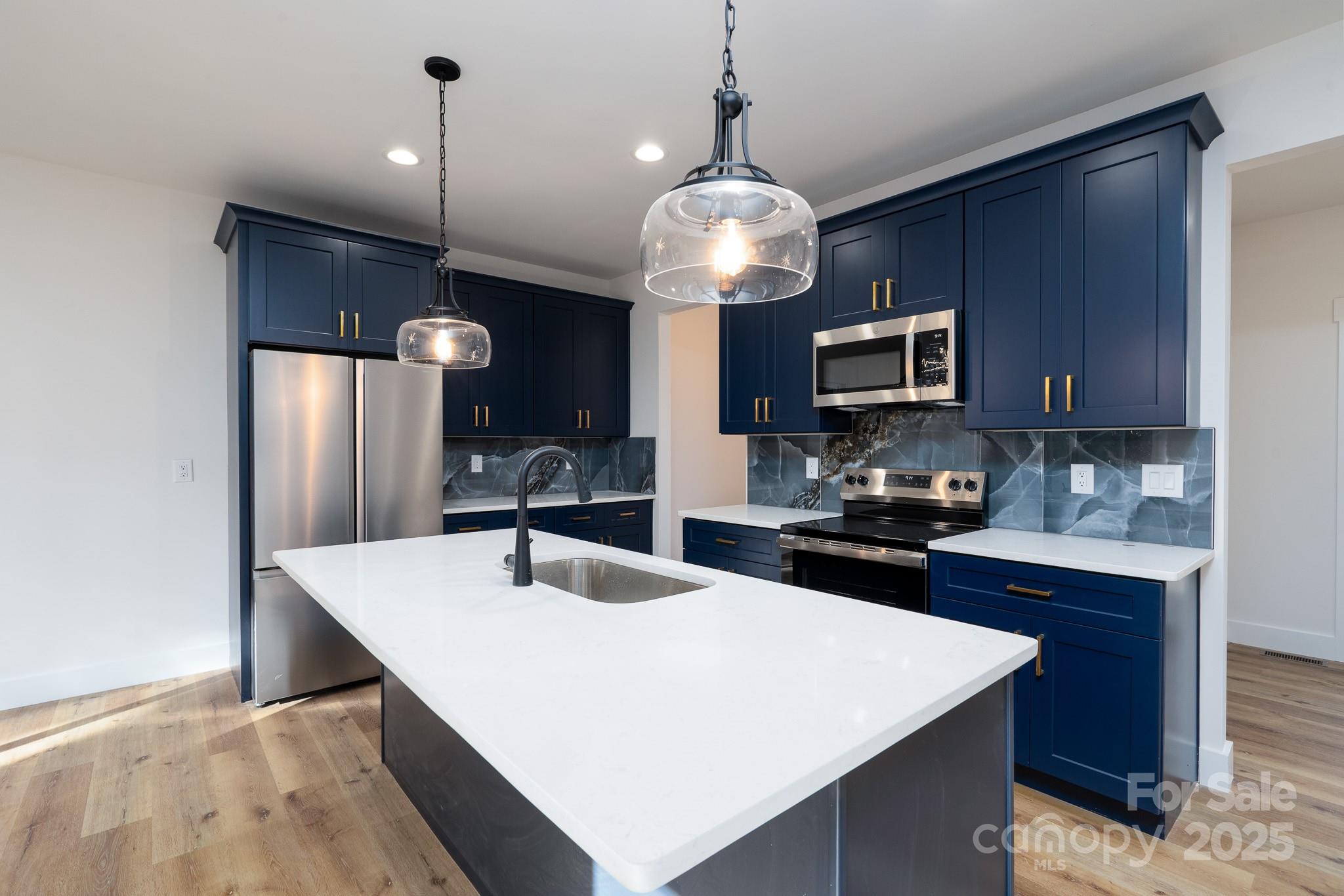 a kitchen with stainless steel appliances a center island refrigerator and cabinets
