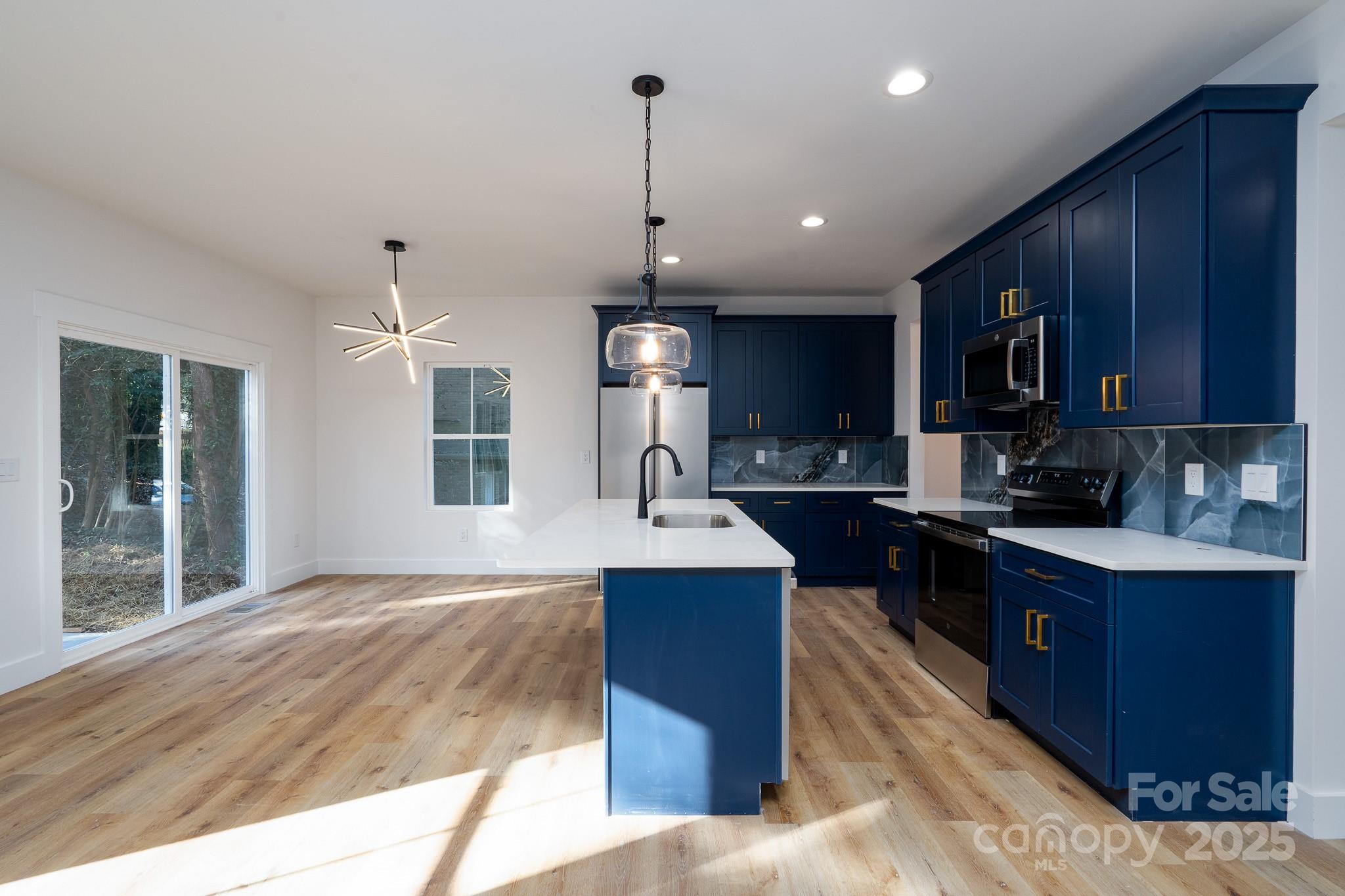 924 Oregon Street Kannapolis, NC 28083 - Photo 23 of 34 a kitchen with kitchen island granite countertop wooden cabinets a sink and dishwasher
