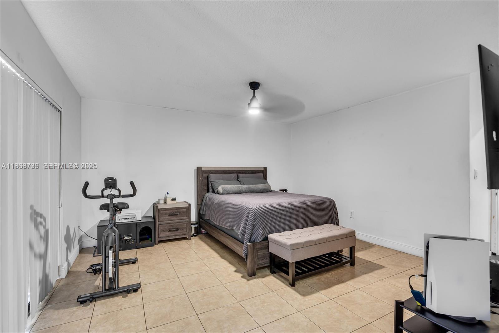 6646 Northwest 175th Terrace Hialeah, FL 33015 - Photo 13 of 33 a bedroom with a bed and a chair