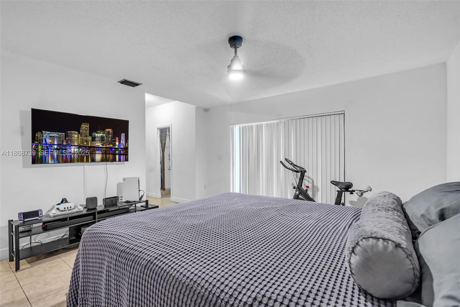 6646 Northwest 175th Terrace Hialeah, FL 33015 - Photo 14 of 33 a bedroom with a large bed and a large mirror