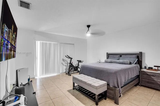 a bedroom with a bed and a flat tv screen on the dresser