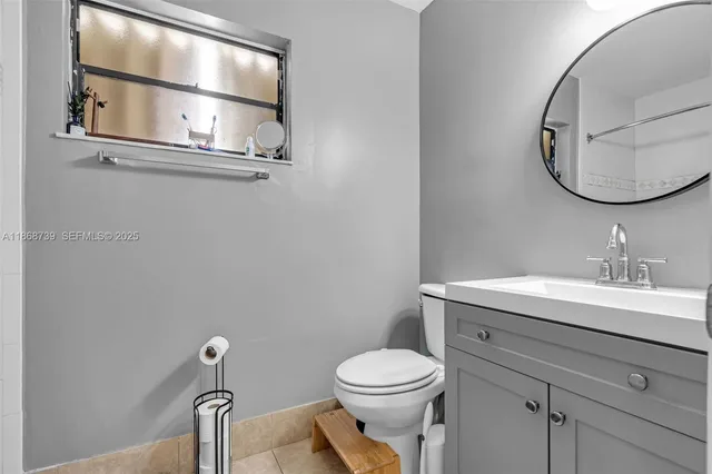 a bathroom with a toilet a sink and mirror