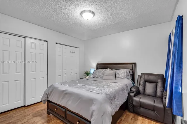 a spacious bedroom with a bed and wooden floor
