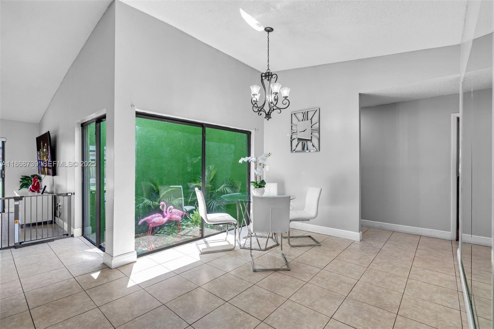 6646 Northwest 175th Terrace Hialeah, FL 33015 - Photo 6 of 33 a view of a dining room with furniture a chandelier and window
