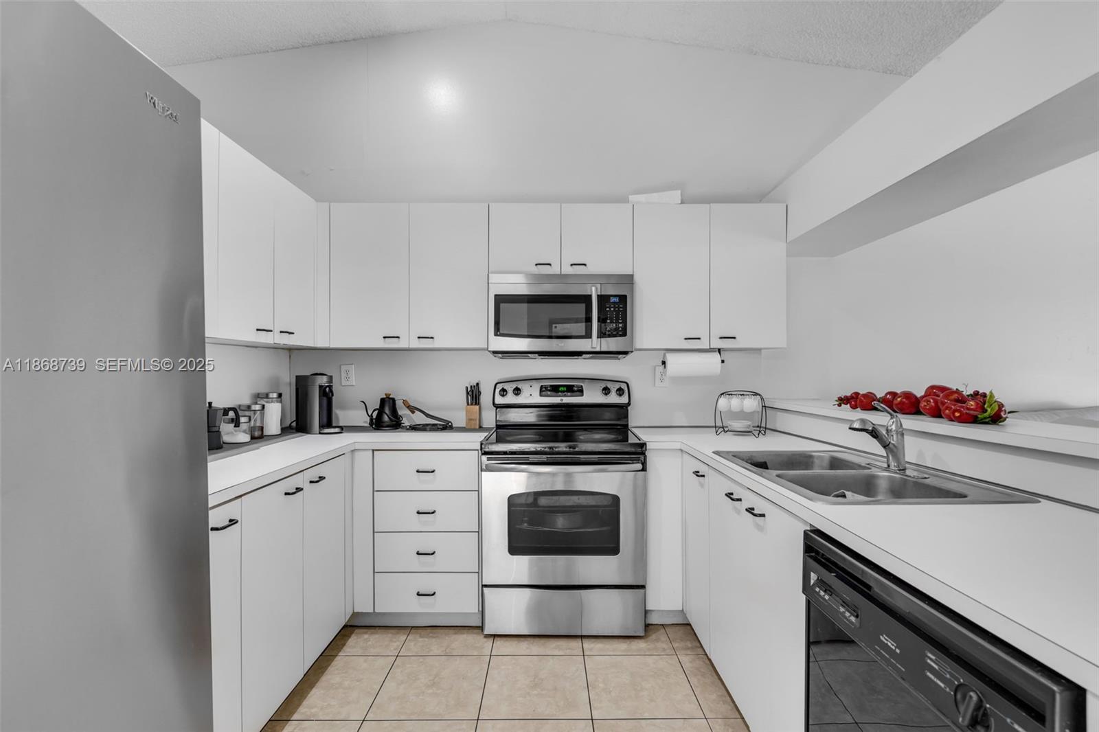 6646 Northwest 175th Terrace Hialeah, FL 33015 - Photo 8 of 33 a kitchen with white cabinets appliances and sink