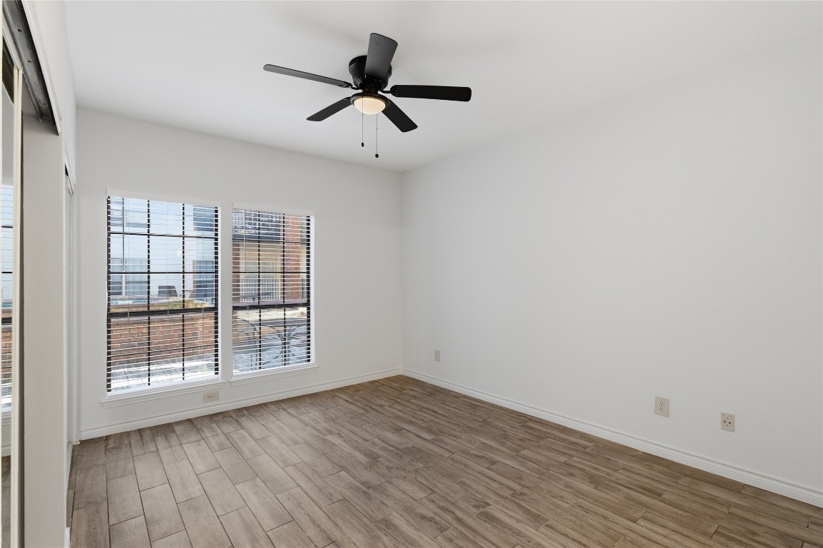 3001 Cedar Street, Unit 116 Austin, TX 78705 - Photo 10 of 14 an empty room with wooden floor fan and windows